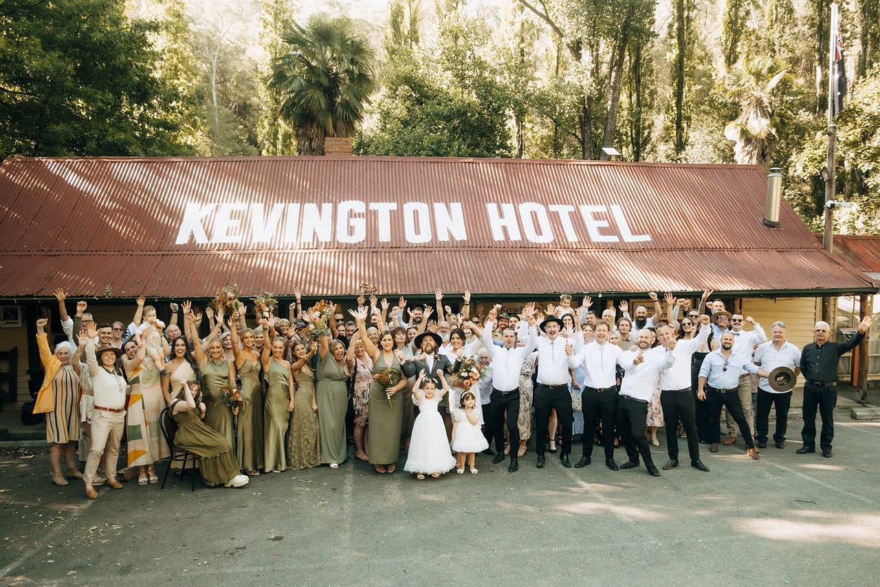 A big group of wedding guests cheering outside the Kevington Hotel