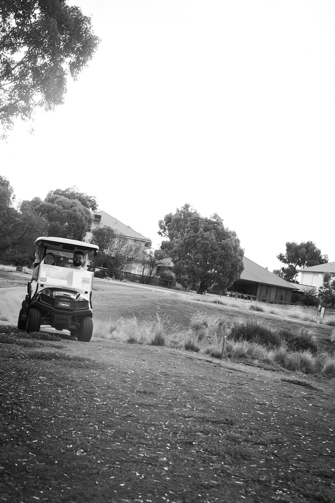 Black and white photo of a golf cart out on the golf course beside the homestead grounds