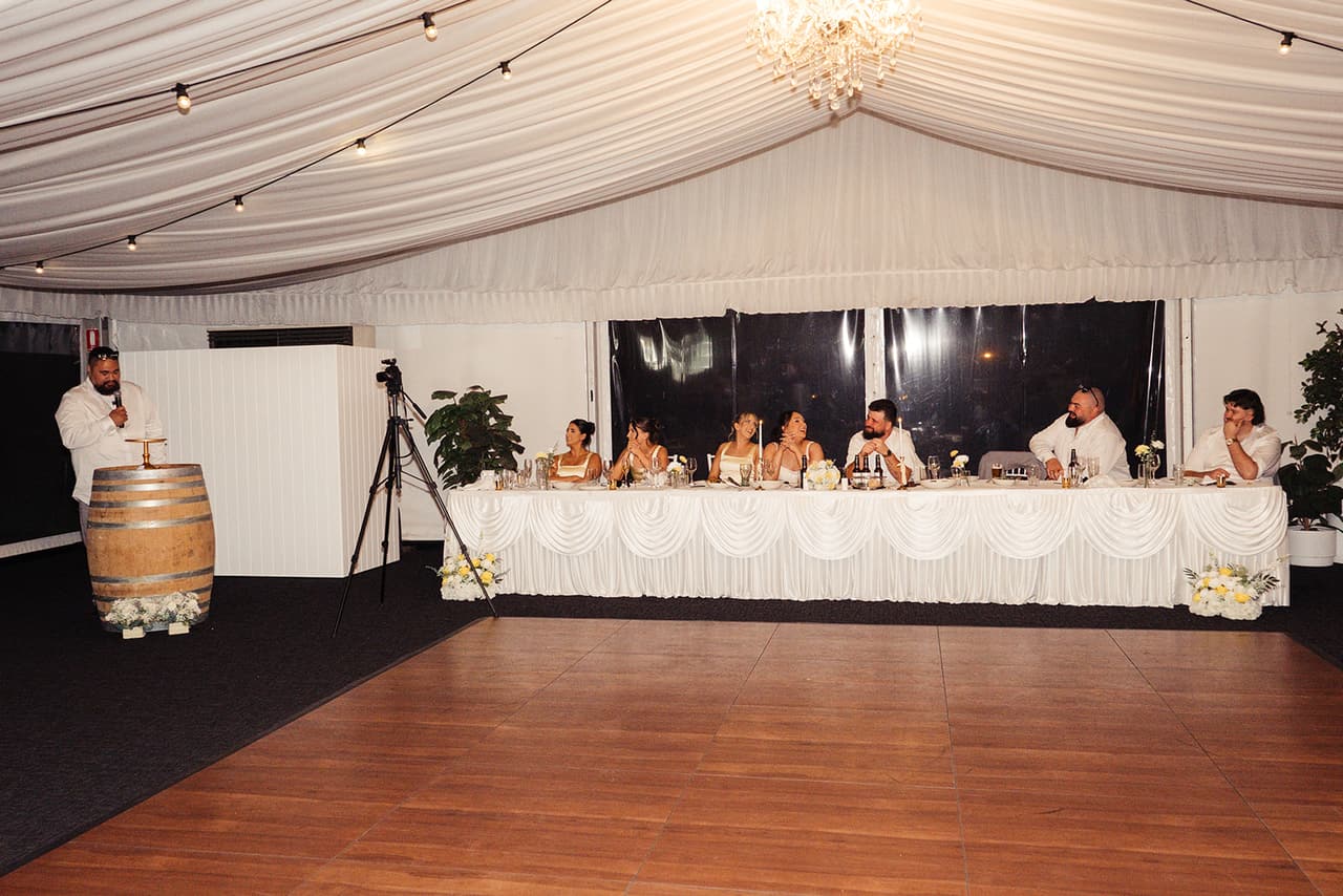 The timber dance floor in front of the long head table, a wine barrel set up for the speeches