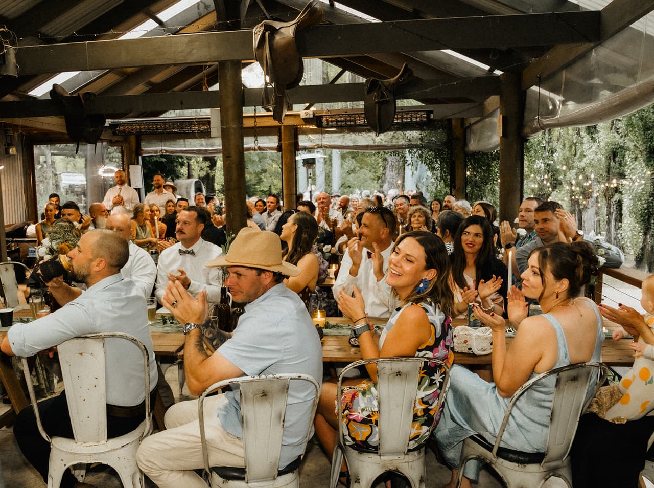 Guests at long tables under the pavilion roof, laughing during the speeches