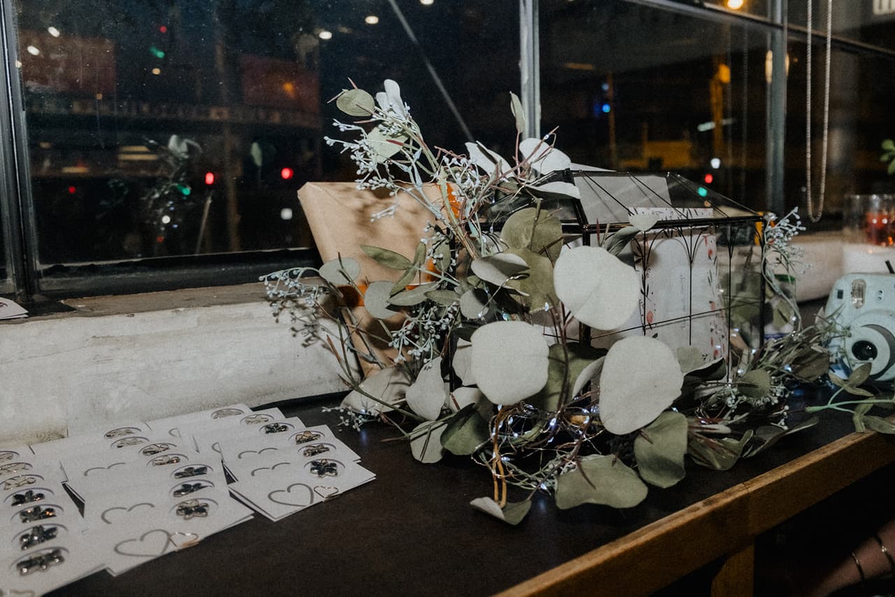 Eucalyptus, a glass card box, an instant camera and rows of heart cards on the bench by the window