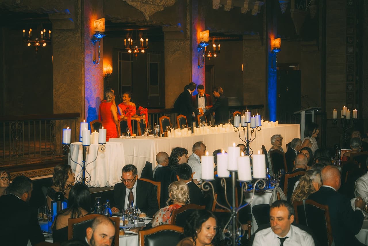 The head table lit by candles, guests seated in front
