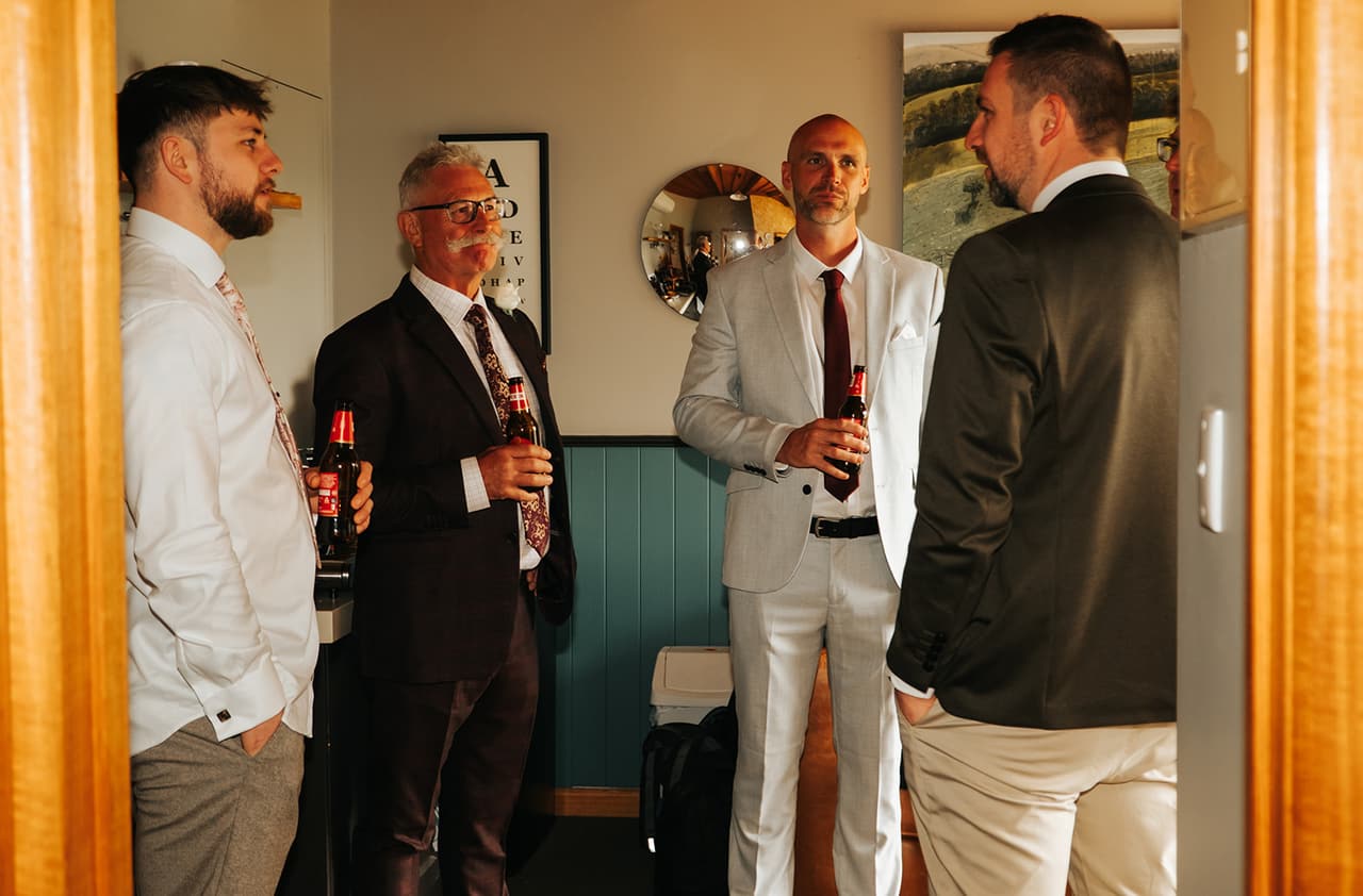 Max and the men of his party with beers in the hallway of their apartment