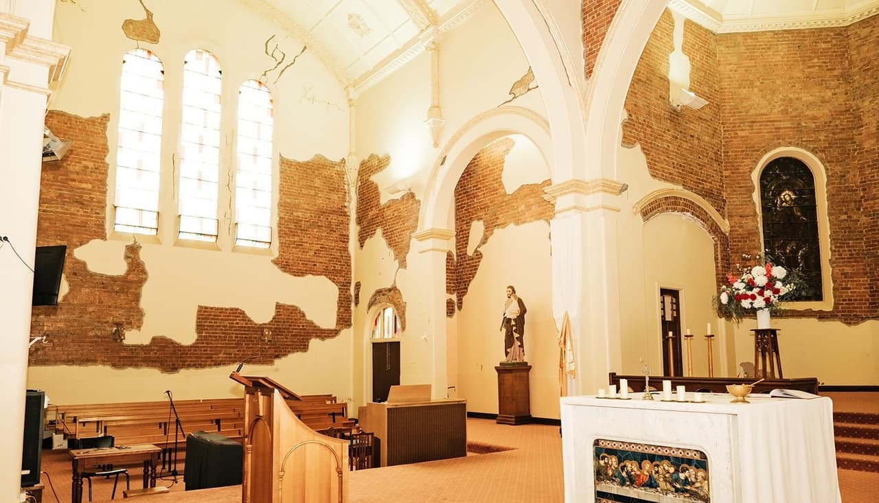Tall arched windows above the side of the sanctuary, the timber lectern and the altar below