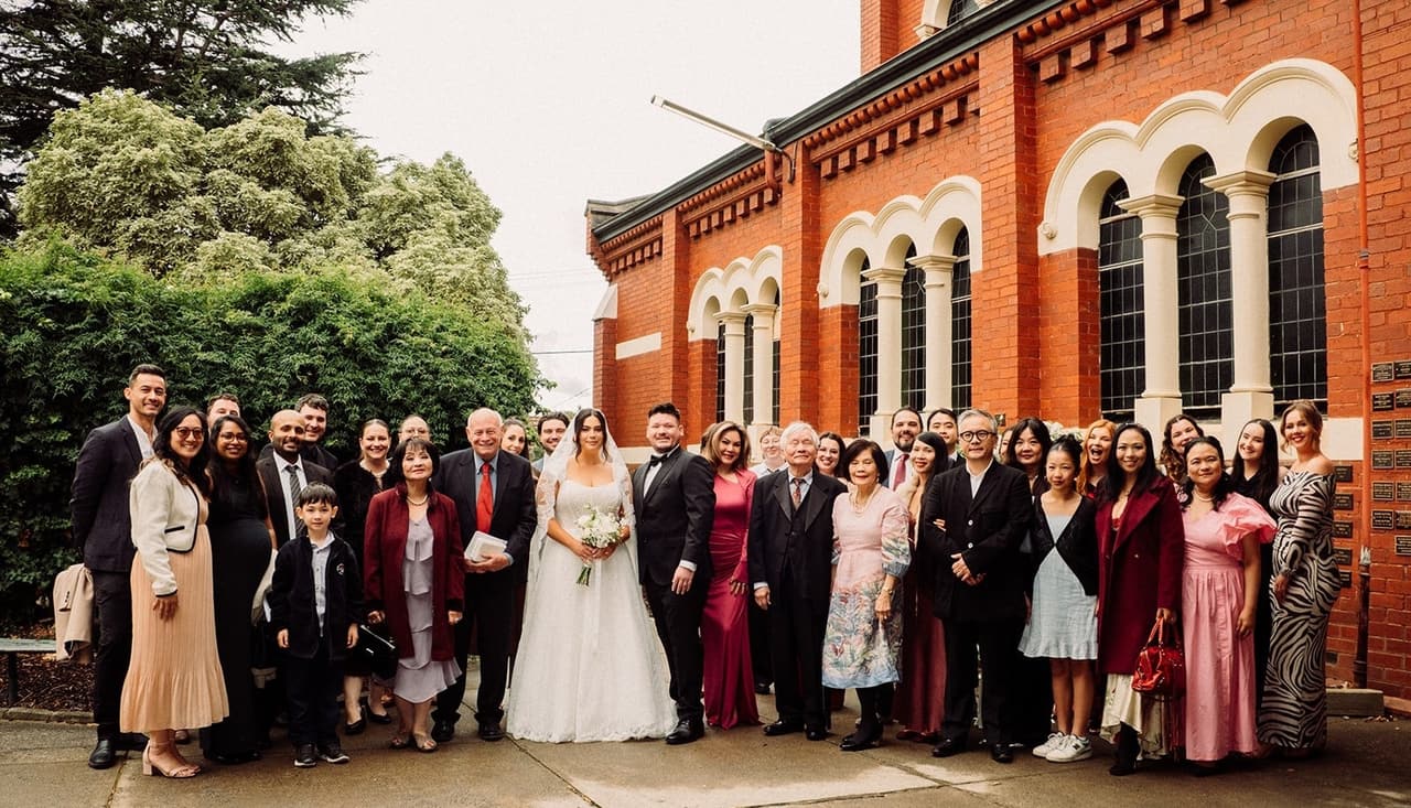 All the guests gathered for a group photo on the paved forecourt in front of the red brick church