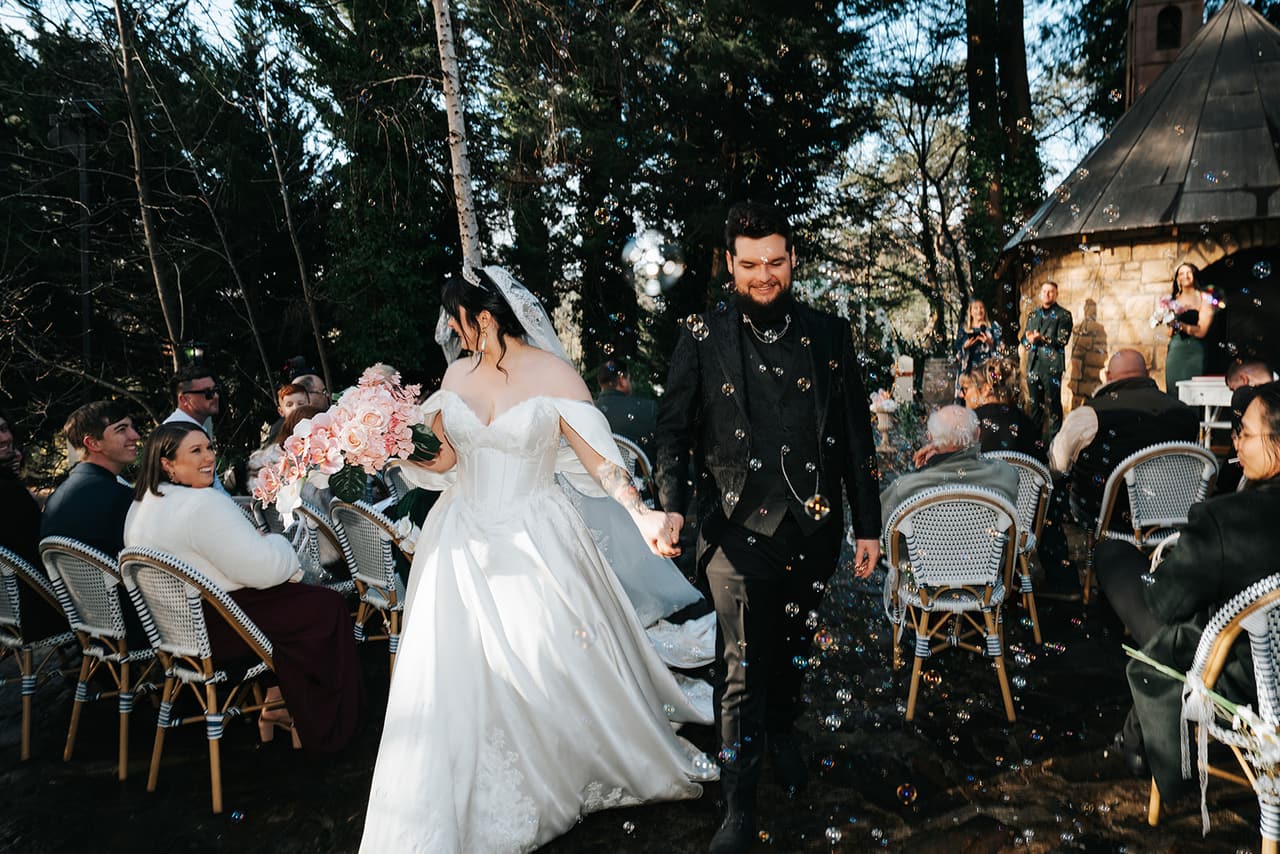 Porscha and Jordan walking back up the aisle as husband and wife while guests cheer
