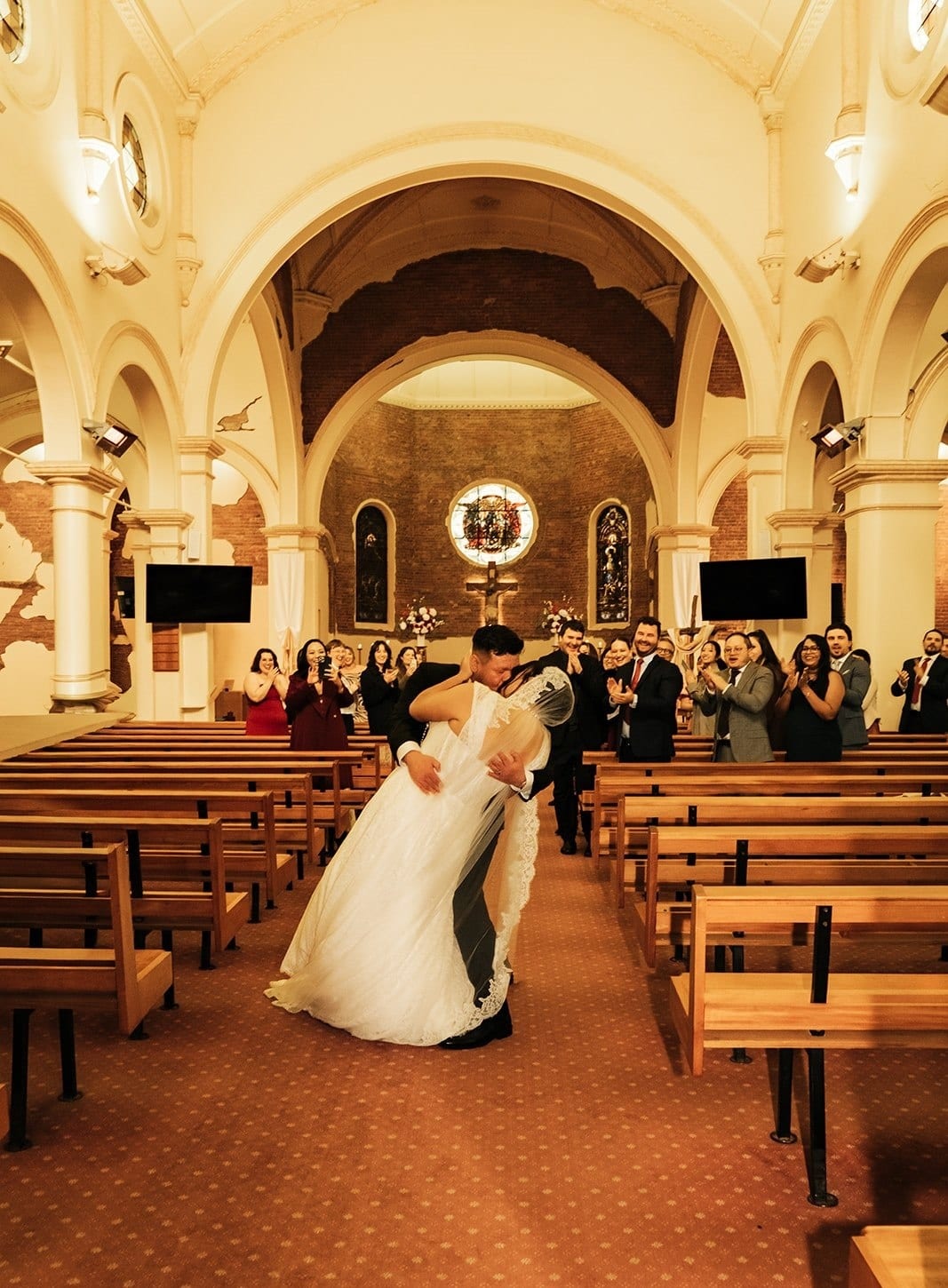 Bryan dipping Ashley for a kiss halfway up the aisle