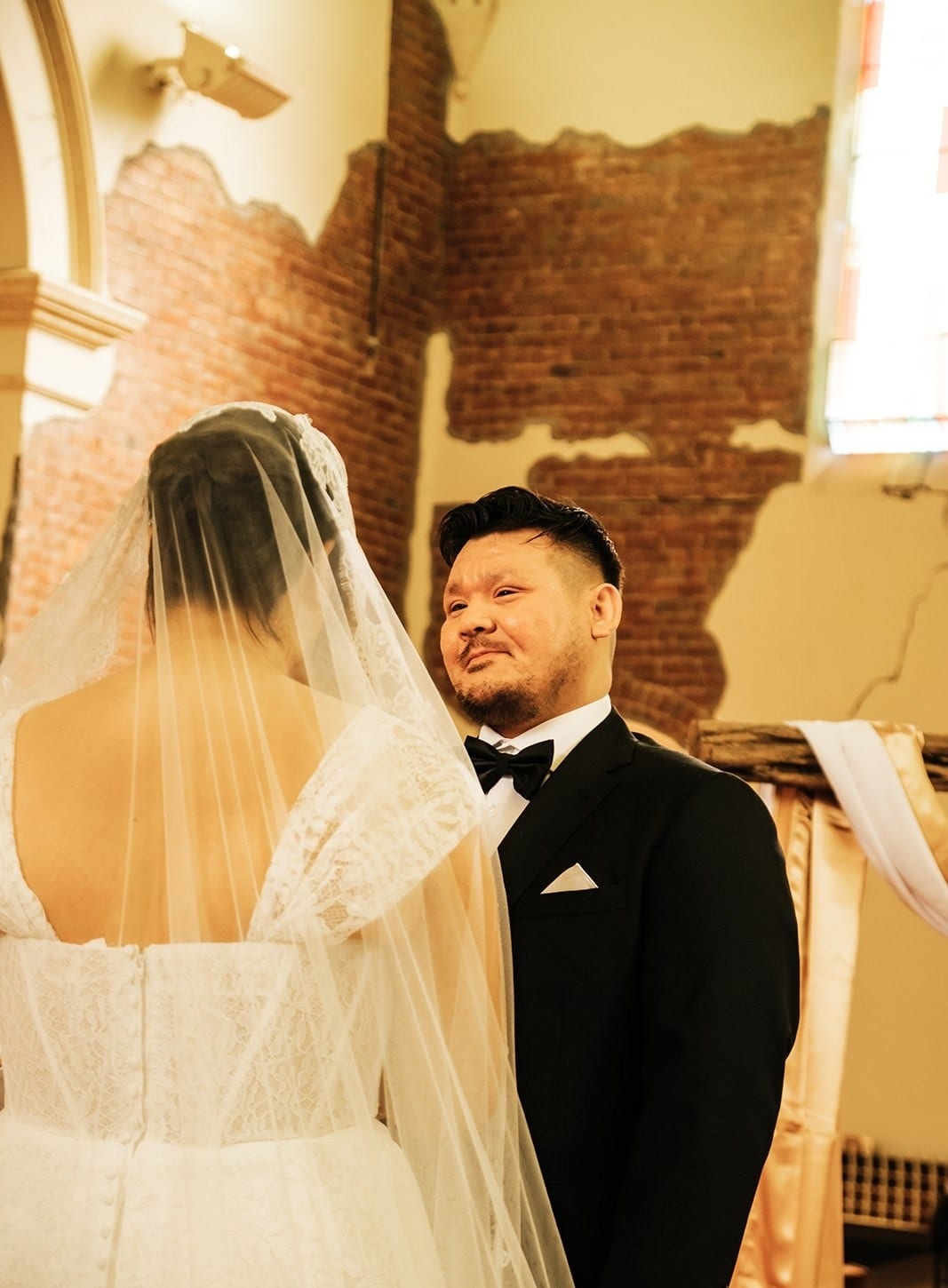 Bryan smiling at Ashley as they hold hands for their vows