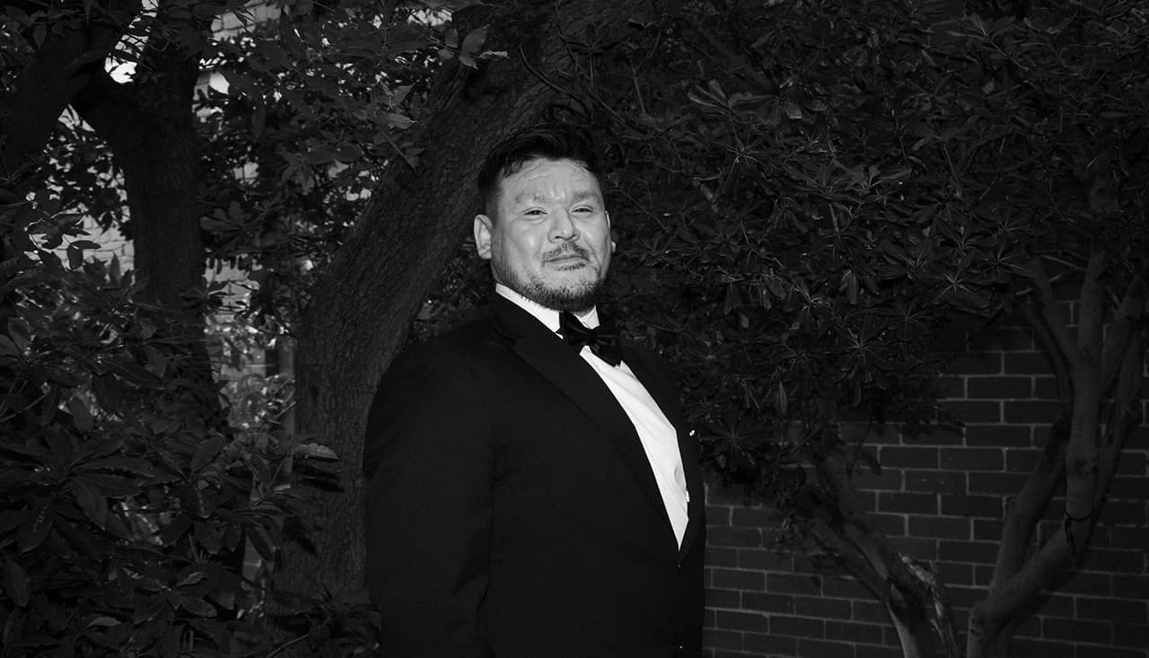Black and white portrait of Bryan in the garden under the trees