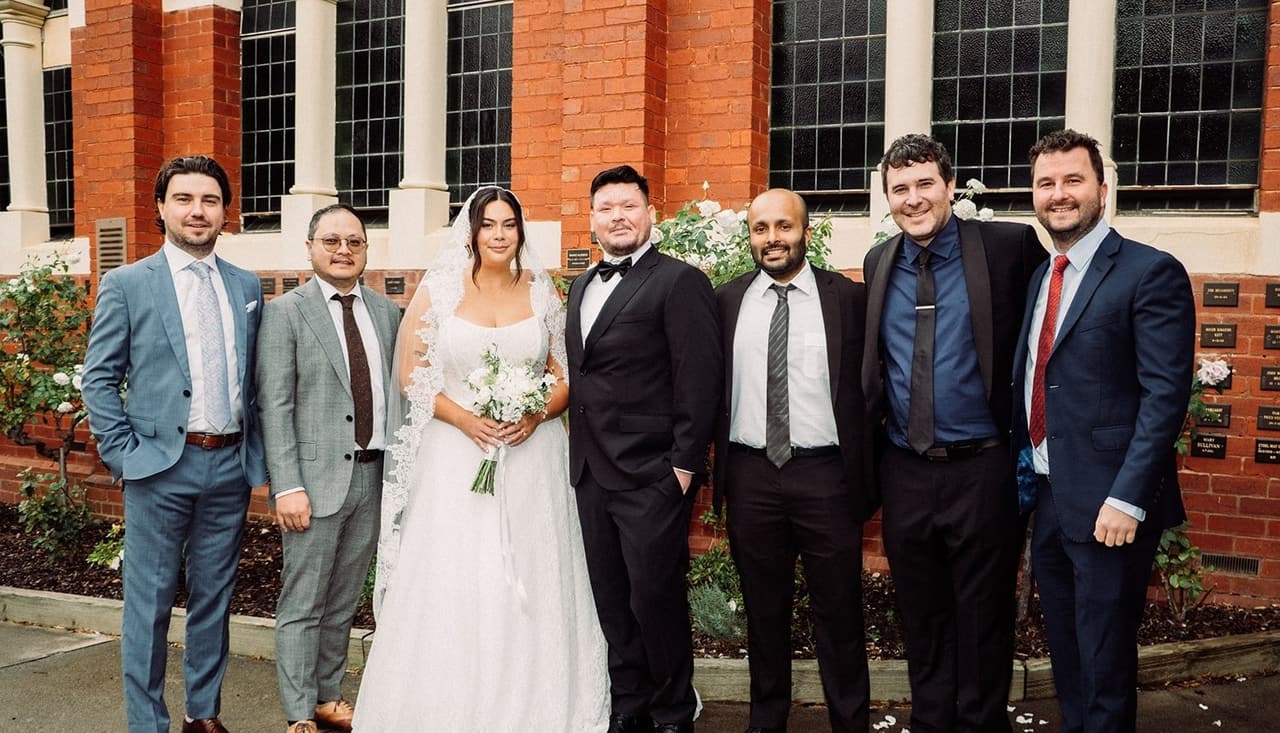 Ashley and Bryan with the groomsmen in front of the church