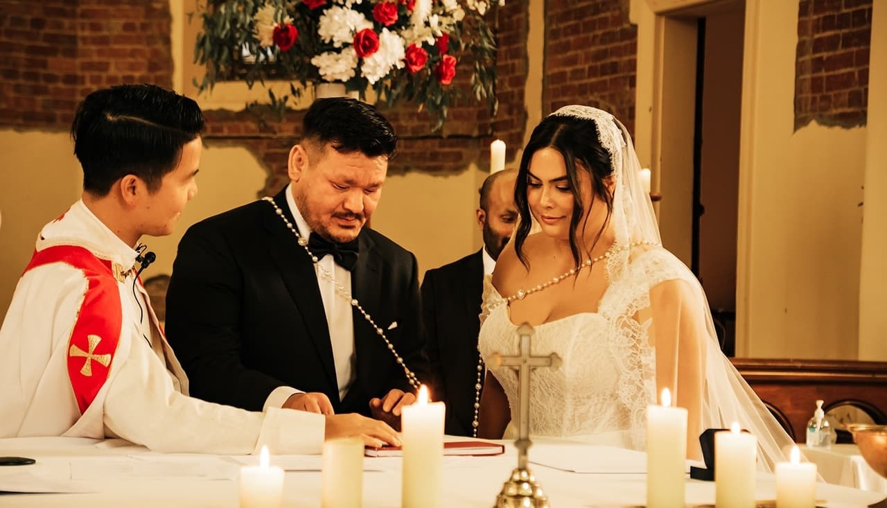 The signing at the altar table behind a row of lit candles and a small cross