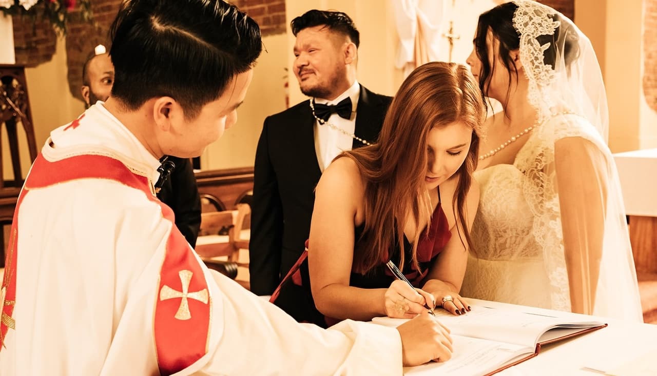 A witness in a red dress signing as Bryan and Ashley laugh beside her