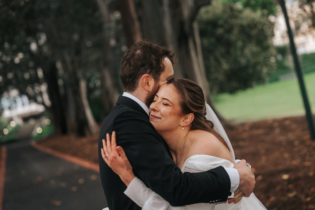 Bianca throwing her arms around Aidan in a laughing hug