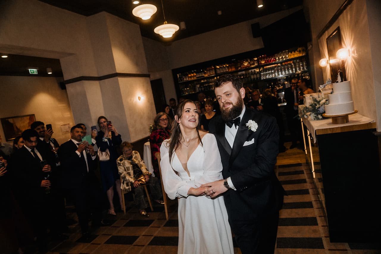 Bianca and Aidan walking into the Cabinet Room at The Imperial Hotel as their guests cheer
