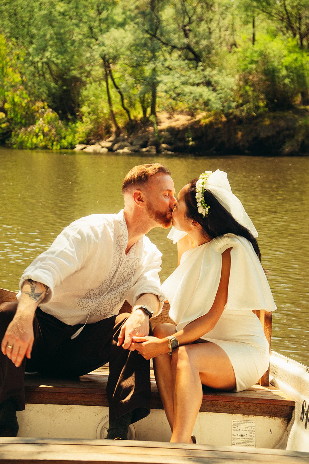 Stefan kissing Cecile as they sit together in a rowing boat on the river
