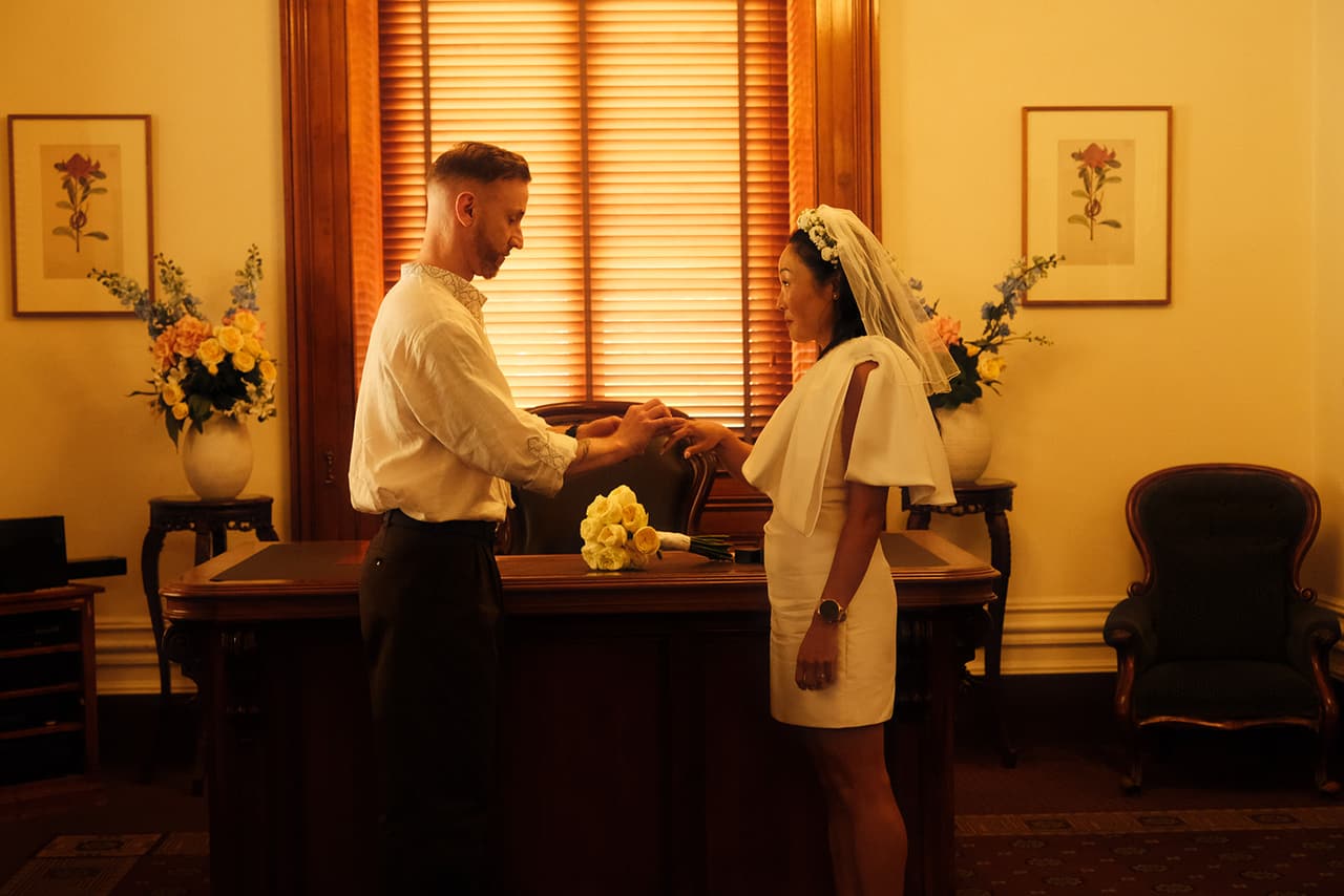 Cecile and Stefan holding hands at the desk during their ceremony