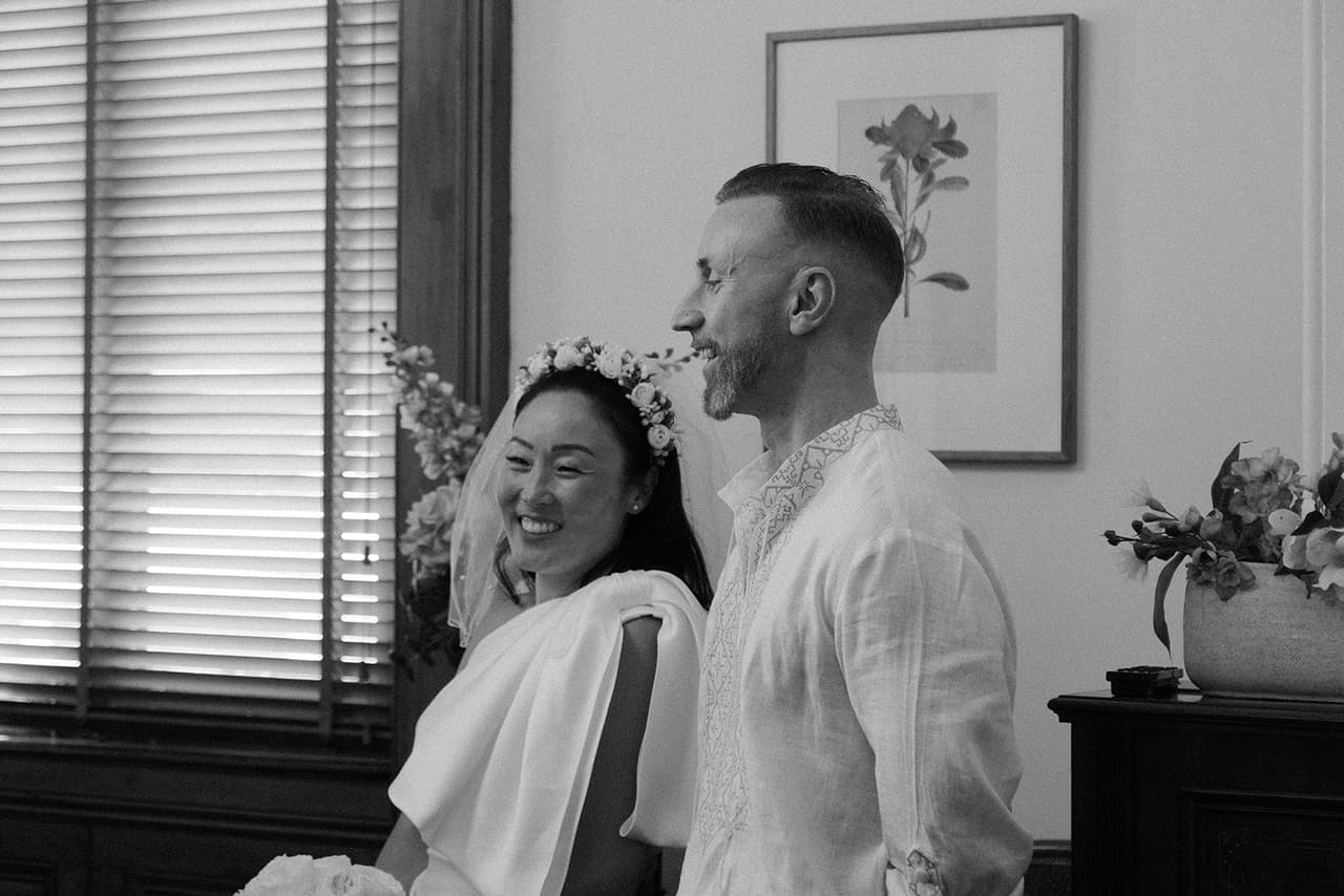 Black and white photo of Cecile and Stefan laughing side by side in the registry room