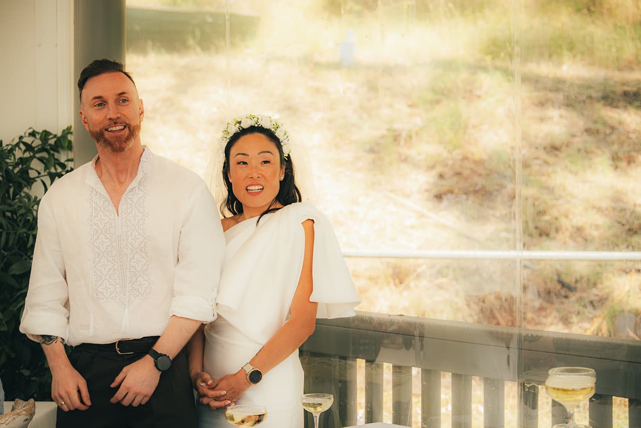 Cecile and Stefan smiling side by side on the boathouse verandah