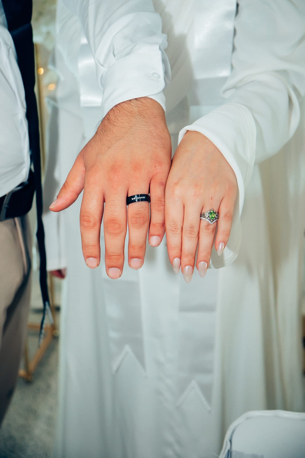 Close up of Yasir’s and Elektra’s hands side by side, showing their rings
