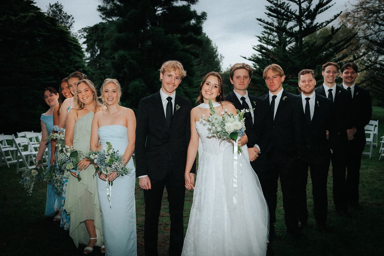 Eli and Charlotte with their bridal party on the lawn