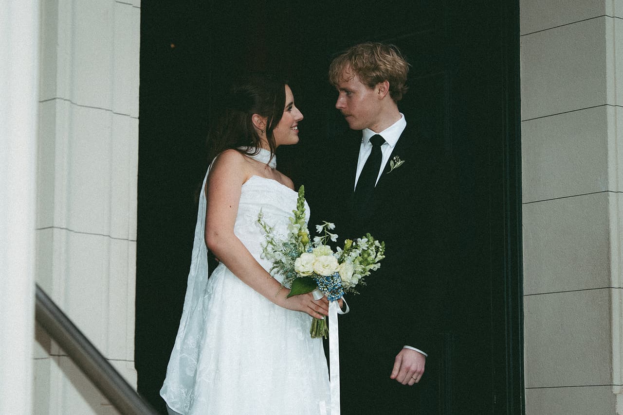 Charlotte and Eli looking at each other in the doorway of the Museum of Economic Botany, a handrail beside them