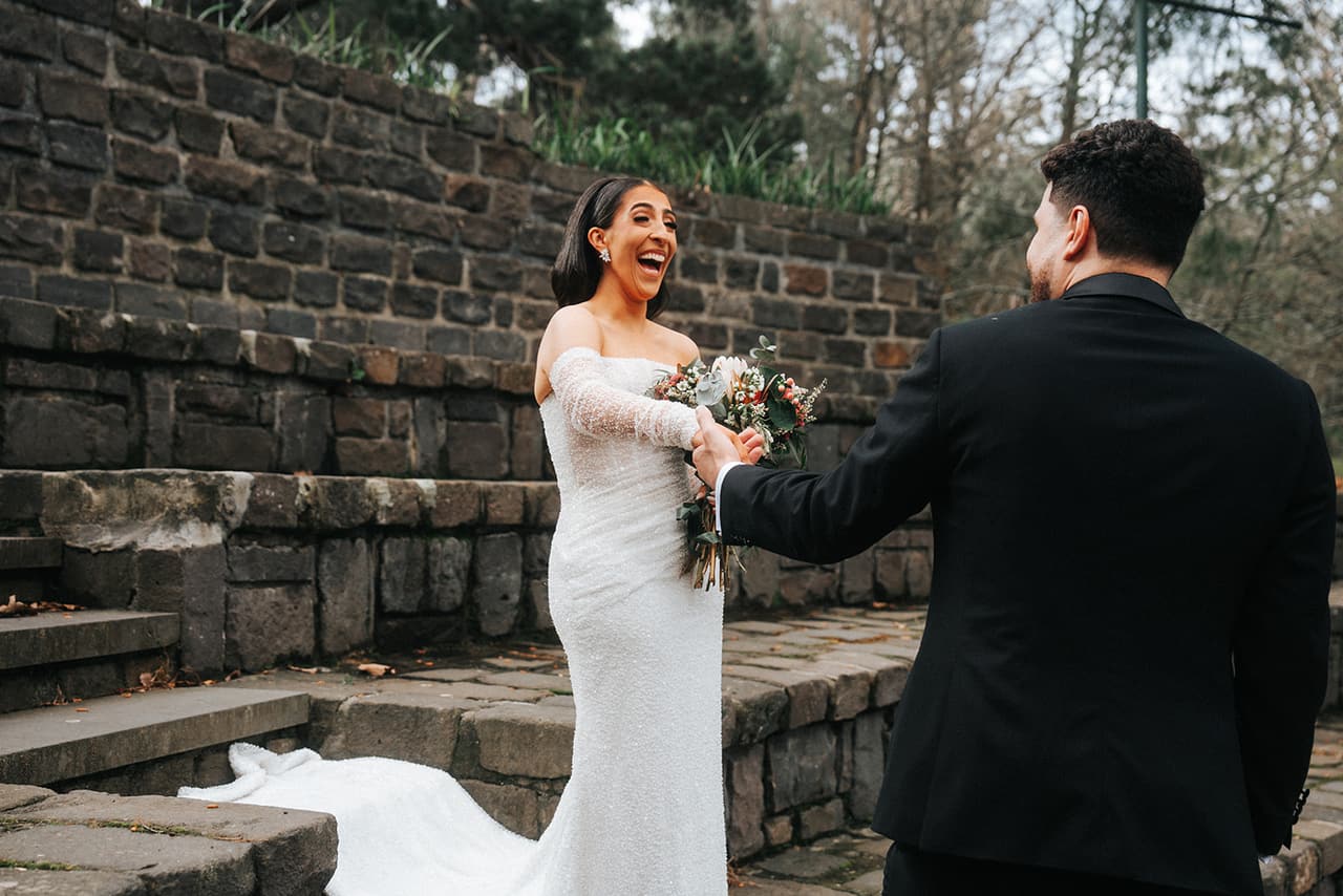 Tia laughing as George reaches for her at their first look on the amphitheatre steps