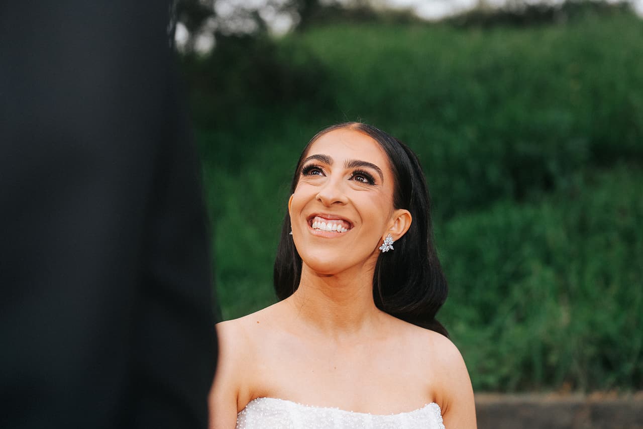 Tia smiling up at George against a soft green background
