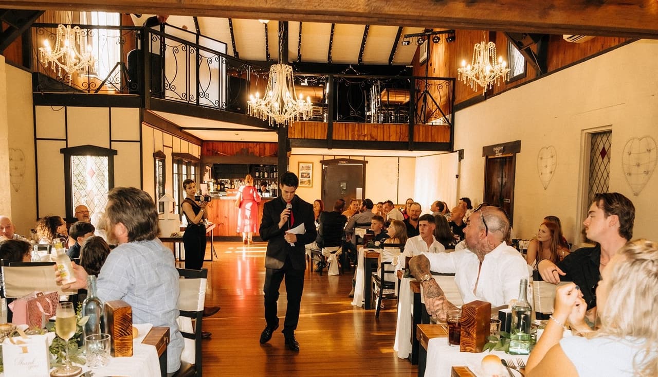 Guests at the long tables watching the bridal party walk into the reception hall