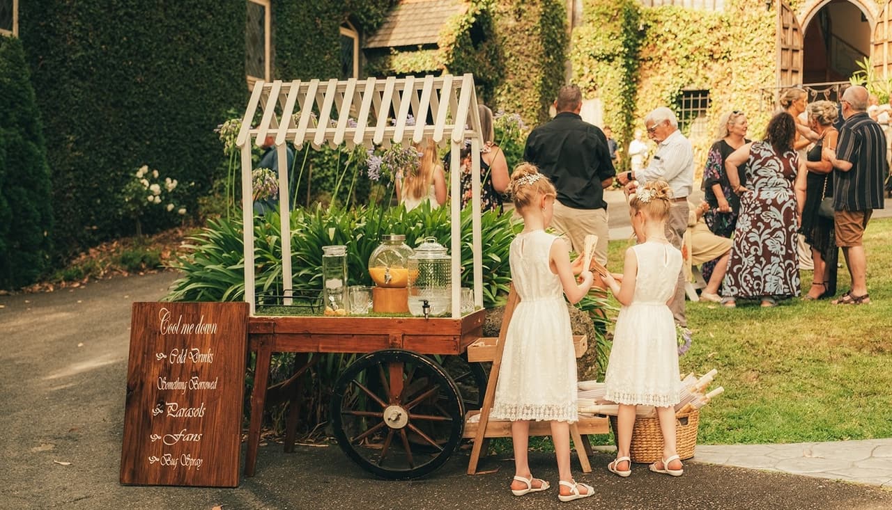 Flower girls by the flower cart and its painted sign offering cold drinks, parasols, fans and bug spray