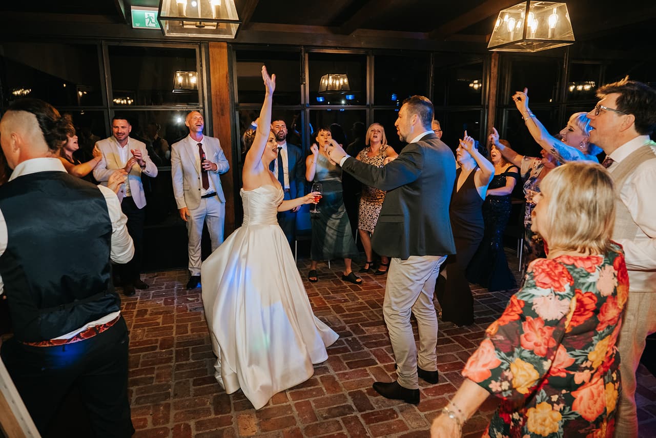 Guests jumping and cheering around Jessica in the middle of the dance floor