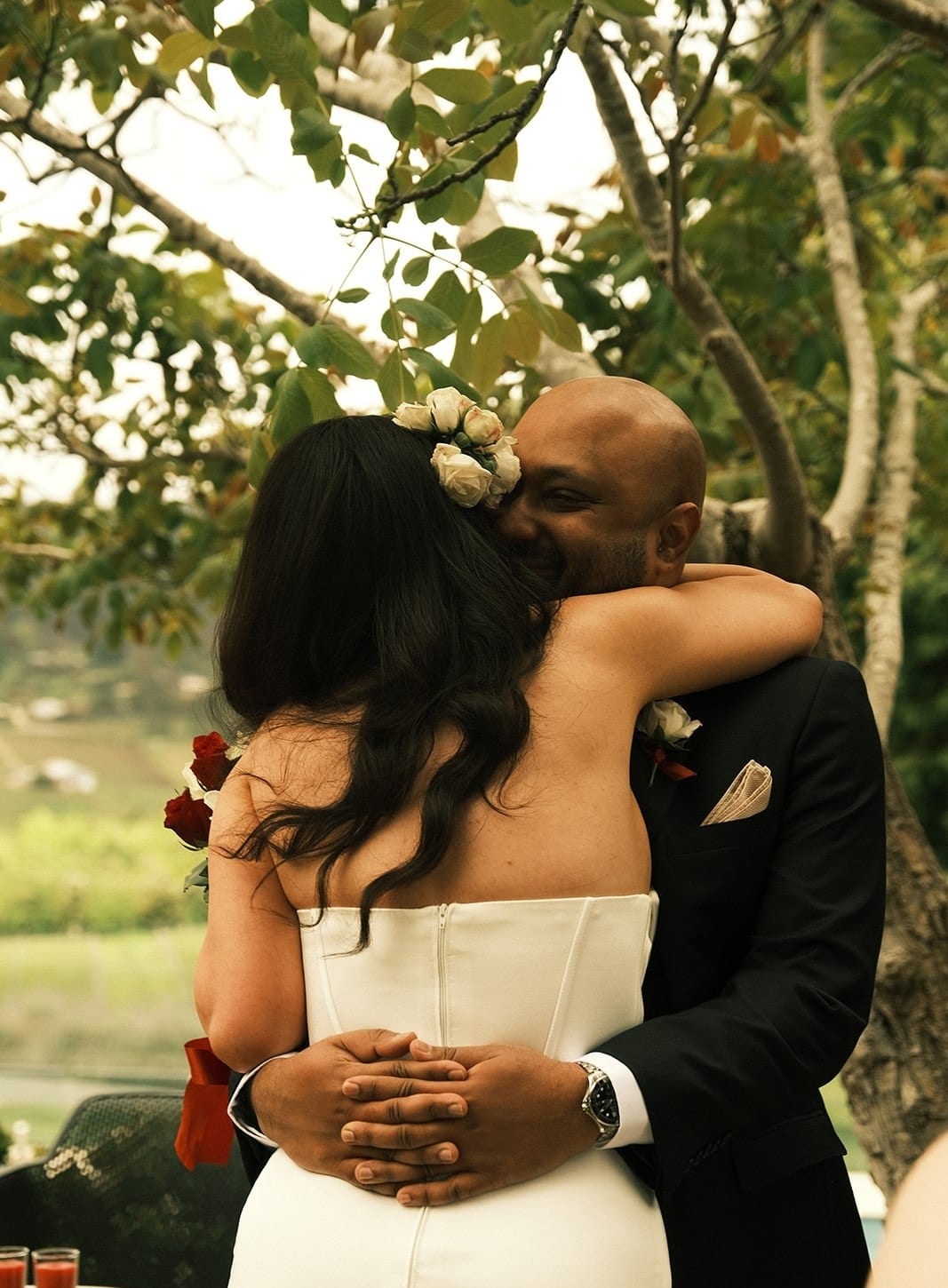 Krish and Joanna holding each other in a long hug under the tree