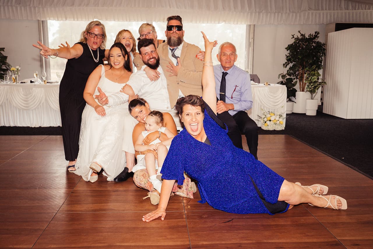 Karina, Bronson and family hamming it up on the dance floor, a woman in blue stretched out in front
