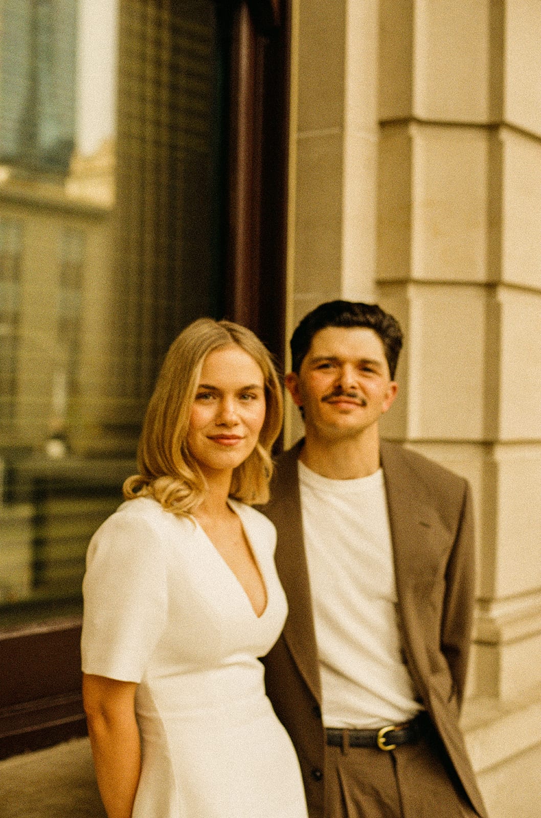 Karina and Chris side by side at the doors of Parliament House, on 35mm film