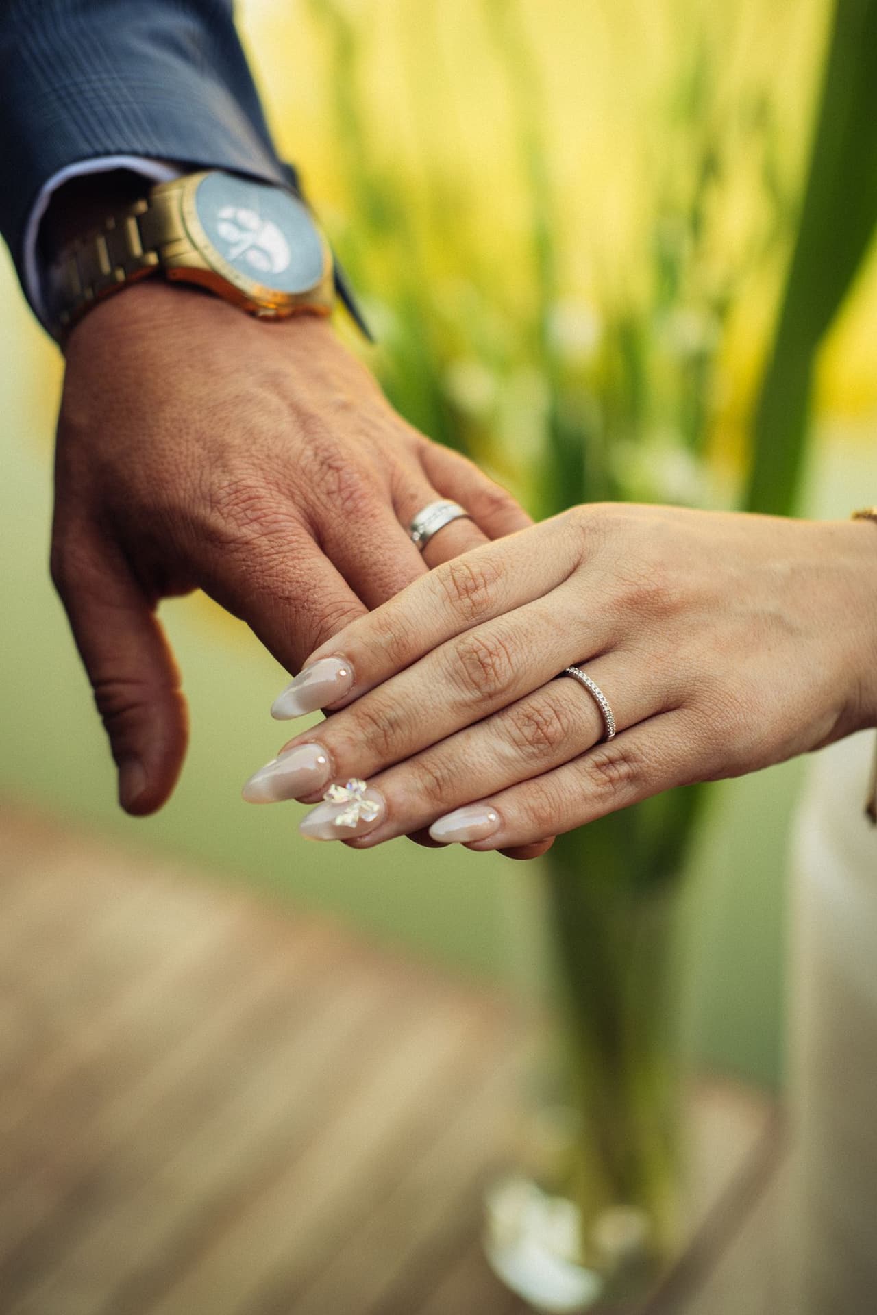 Close up of Ben’s and Kim’s hands resting together, both wedding rings showing