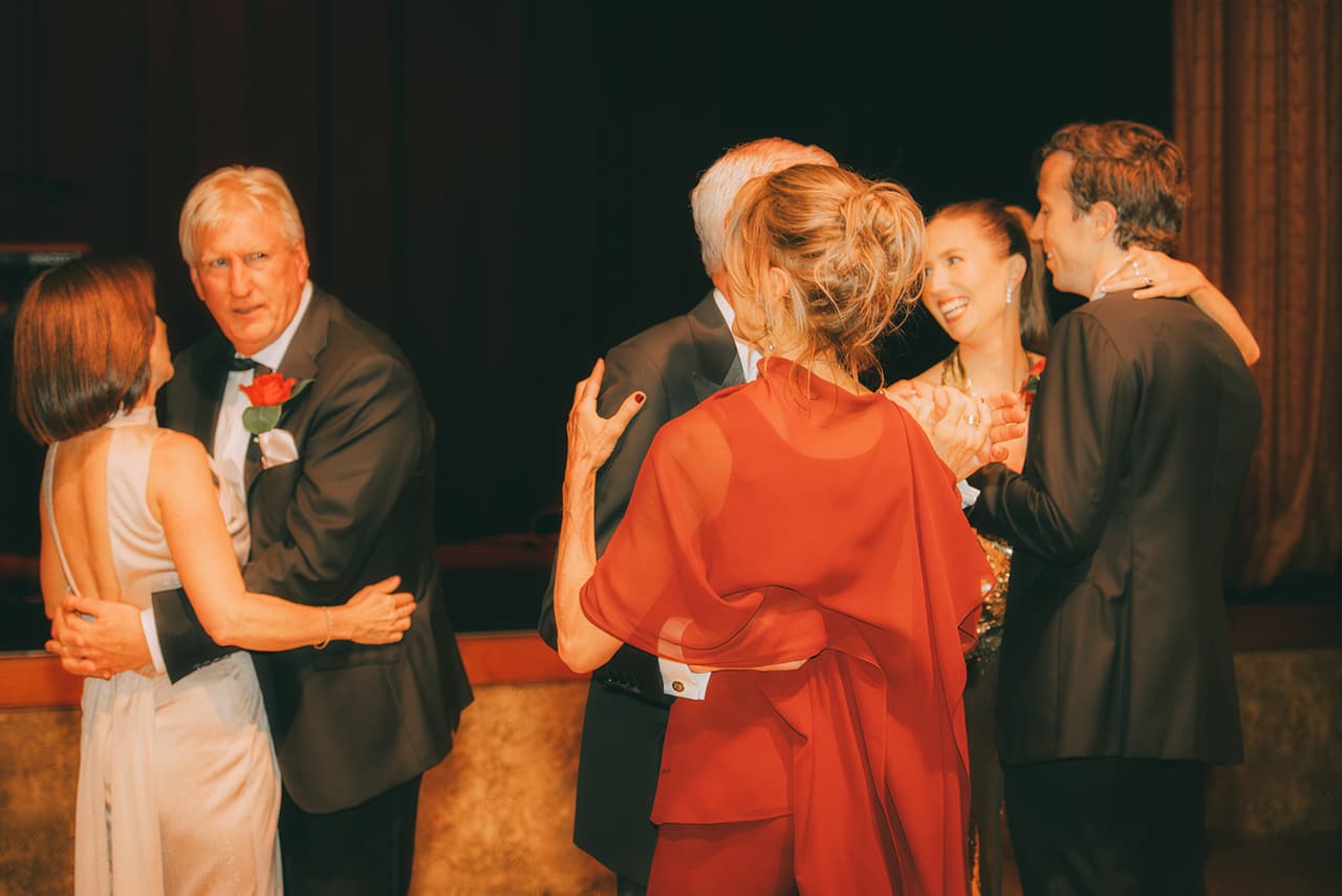 Family members hugging Kira and Nick on the dance floor