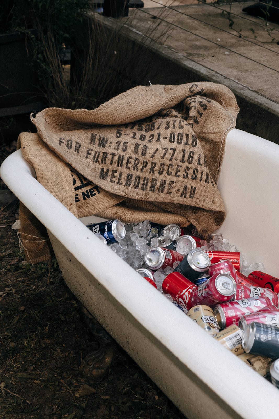 Cans of beer on ice in an old claw-foot bathtub