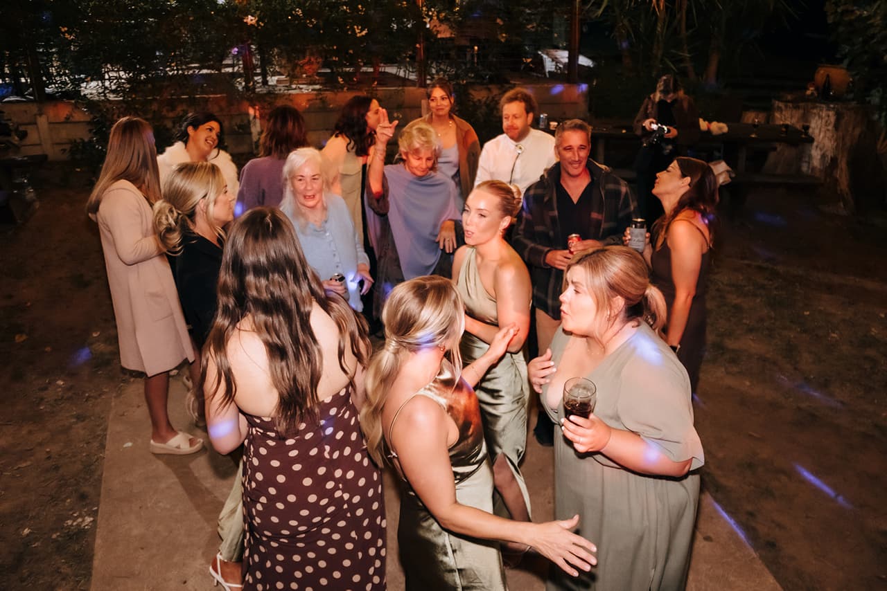 A crowd of guests dancing under the lights late in the night