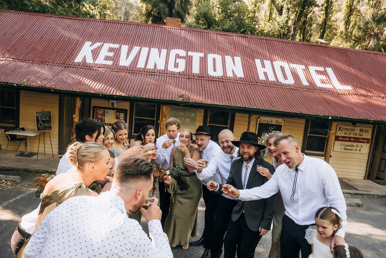Todd and the bridal party downing shots together in front of the Kevington Hotel