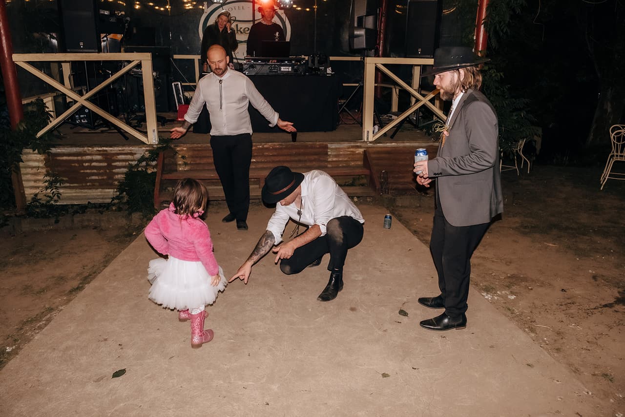 A guest crouching for a dance-off with a little girl in a pink jacket and pink cowboy boots
