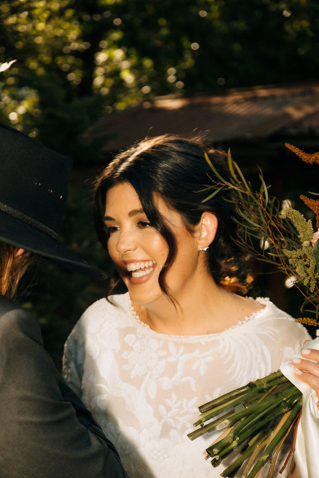Lana laughing with her bouquet in the late afternoon light