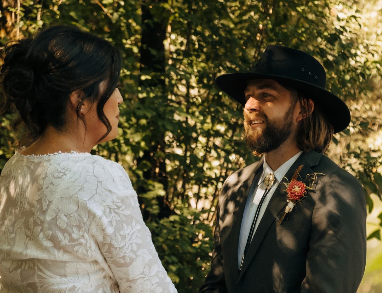 Lana and Todd facing each other during their vows, his hat tipped back
