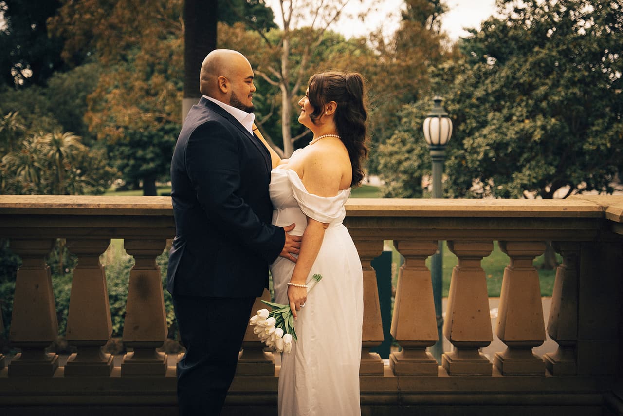 Martina and Diego looking at each other on the balcony above the gardens
