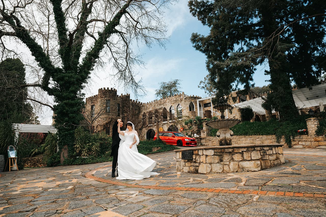 Jordan twirling Porscha in the stone courtyard in front of the ivy-covered castle