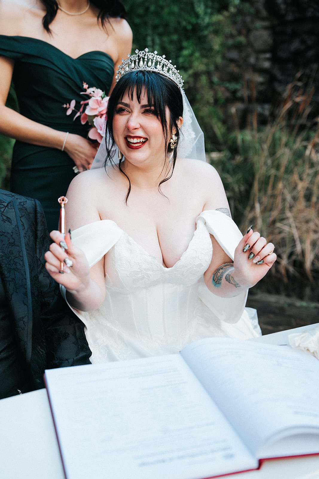 Porscha laughing as she signs at the white desk