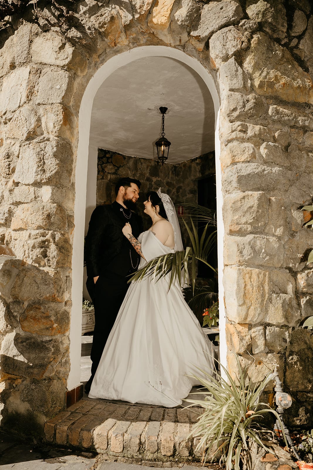 Porscha and Jordan standing together in a deep stone archway in the castle walls