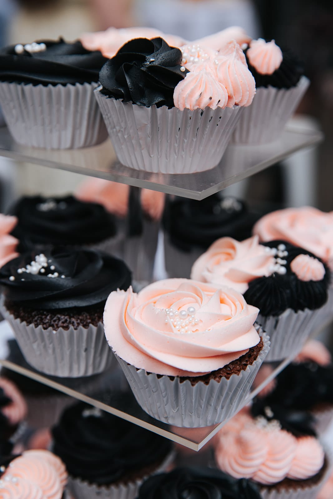 Pink and chocolate cupcakes on a clear stand