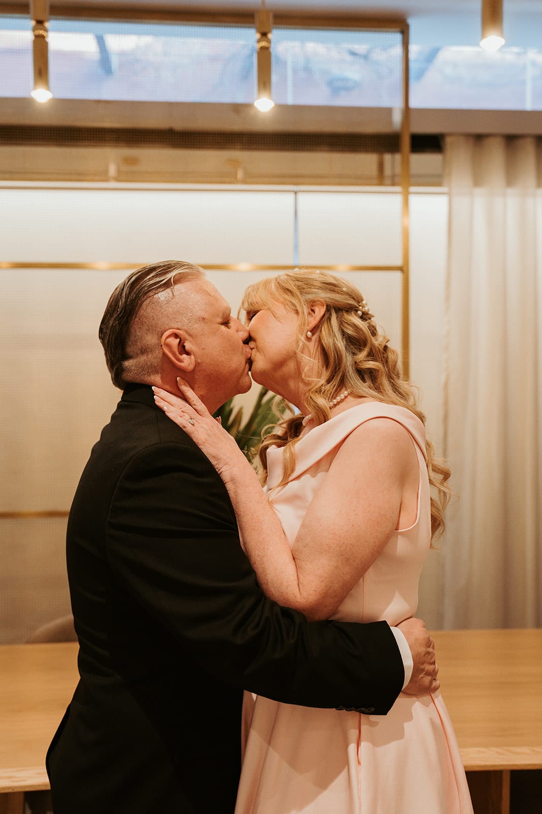Jon holding Terrie’s face as they kiss after the vows