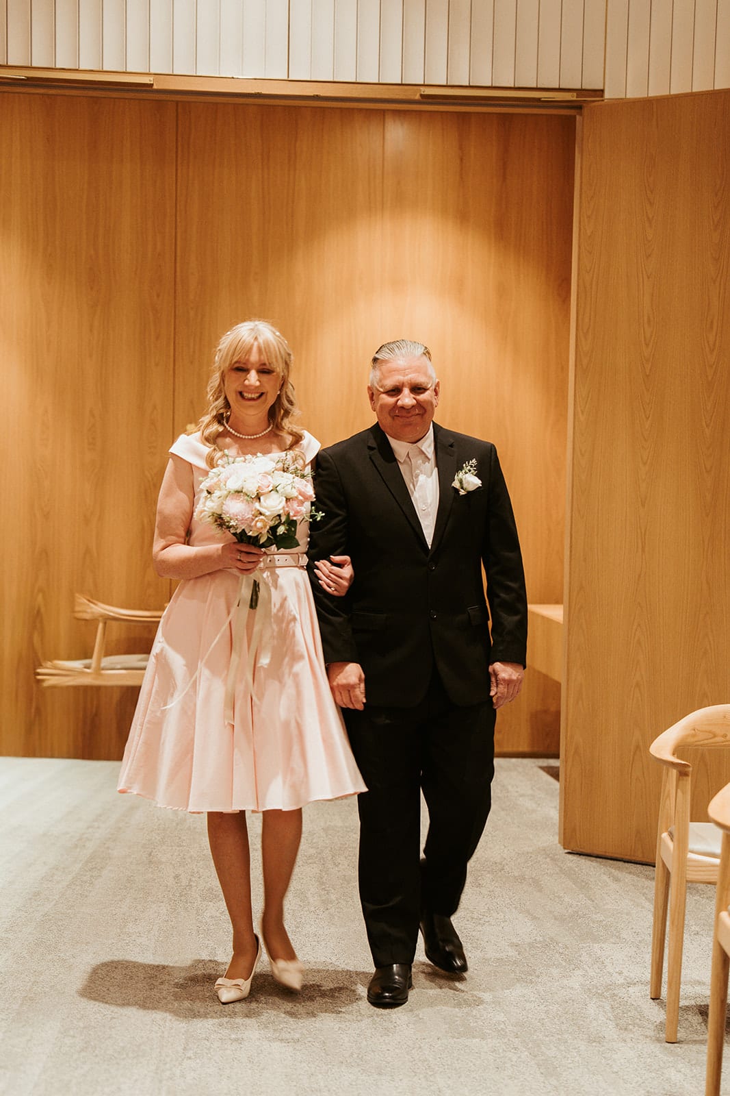 Terrie and Jon walking into the ceremony room at the registry office, arm in arm